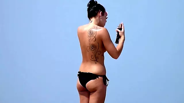 Classless chick with big tits and tattoo's on a beach